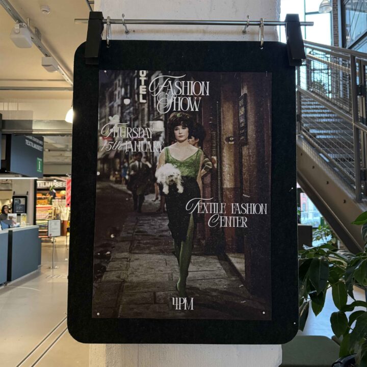 En tjej går på en trottoar, iförd grön top och tights och en svart kjol.